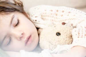 Kid sleeping with a teddy