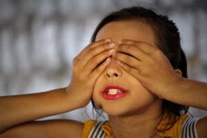 Girl closing eyes with both hands