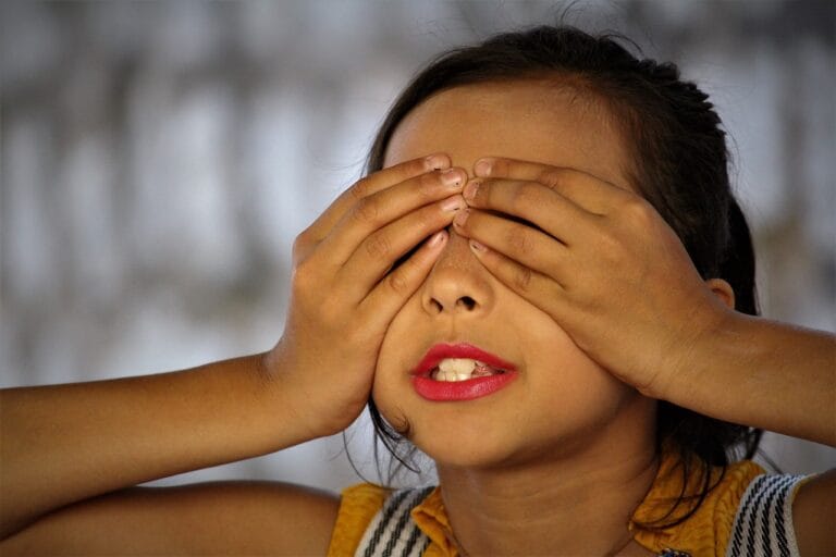 Girl closing eyes with both hands