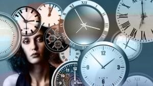woman, behind a bunch of clocks